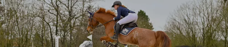 Cavalière en carrière qui saute avec son cheval